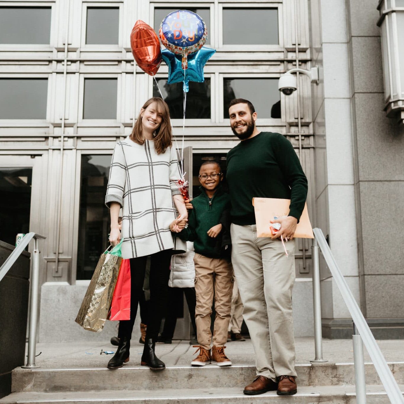Photos of adoptive family on adoption day Buffalo New York. Parents are caucasian. Son is African American and 9 years old. Family is joyful.